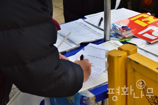 한 집회 참가자가 국민노동조합 회원가입 신청서를 작성하고 있다. (사진=평화나무)