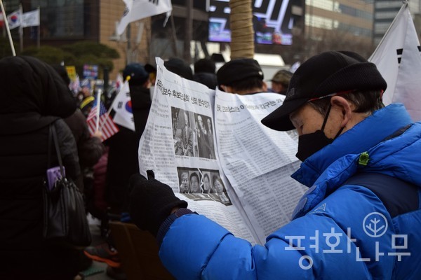 ‘문재인하야 국민총궐기 대회’ 참석자가 현장에서 배포된 ‘자유대한’ 신문을 보고 있다. (사진=평화나무)