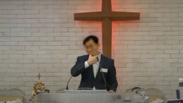 하나님의 불로 자신의 손에 세균이 없다며 자신의 손가락을 빨고 있는 목사(출처=유튜브)