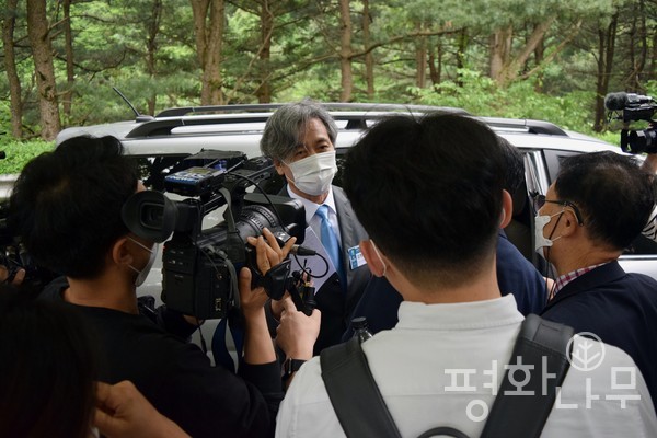 임시노회가 끝나자 황급히 자리를 떠난 김명진 목사가 자신의 차량 앞에서 기자들의 질문에 답변하고 있는 모습. (사진=평화나무)